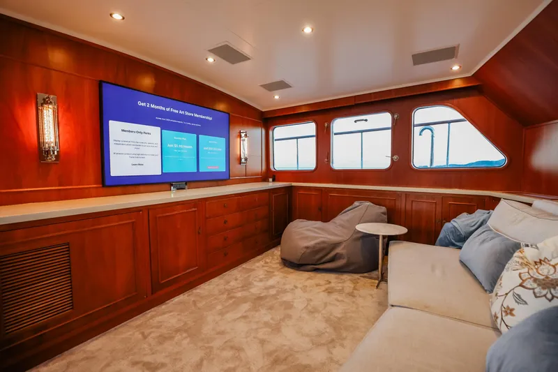 Kapal Yacht Photos Pics Luxurious 1971 Feadship yacht interior with wood paneling, plush seating, and large windows.