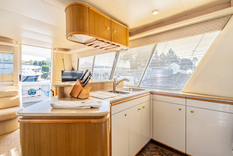 Hyve Yacht Photos Pics Interior of 2001 Bayliner 4788 Pilothouse yacht, featuring a modern kitchen with wood accents.