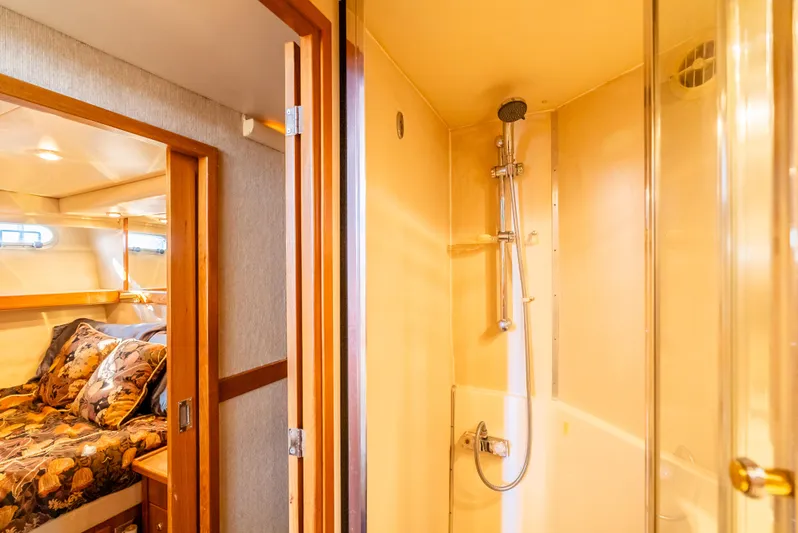 Hyve Yacht Photos Pics Interior of 2001 Bayliner 4788 Pilothouse, featuring a cozy bedroom and modern shower.