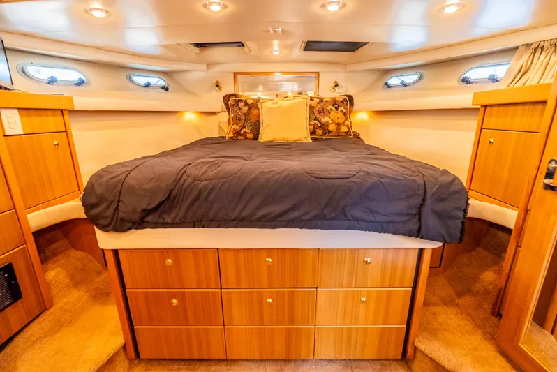 Hyve Yacht Photos Pics Luxurious bedroom interior of 2001 Bayliner 4788 Pilothouse yacht with wood cabinetry and plush bedding.