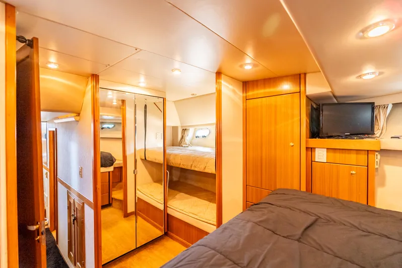 Hyve Yacht Photos Pics Interior of 2001 Bayliner 4788 Pilothouse yacht, featuring cozy bedroom with wood finishes.