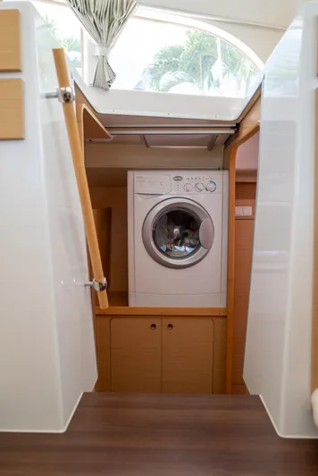Dream Seeker Yacht Photos Pics Washing machine inside Lagoon 380 S2 catamaran, 2011 model, with wooden cabinetry and natural light.