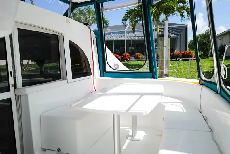 Dream Seeker Yacht Photos Pics Lagoon 380 S2 catamaran cockpit with seating and table, surrounded by lush greenery.