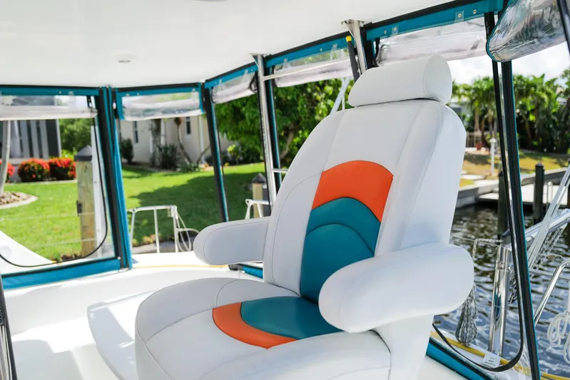 Dream Seeker Yacht Photos Pics Captain's chair on 2011 Lagoon 380 S2 catamaran, featuring colorful upholstery and marina view.