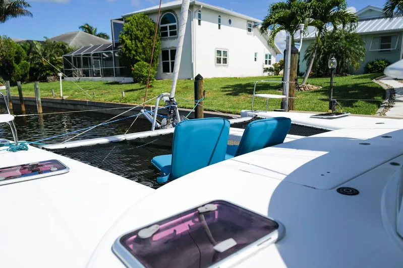 Dream Seeker Yacht Photos Pics Lagoon 380 S2 catamaran, 2011 model, docked near waterfront homes with lush greenery.