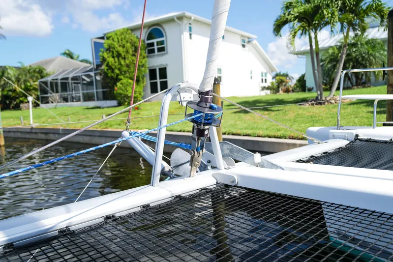Dream Seeker Yacht Photos Pics Lagoon 380 S2 catamaran detail near waterfront home, showcasing rigging and netting.