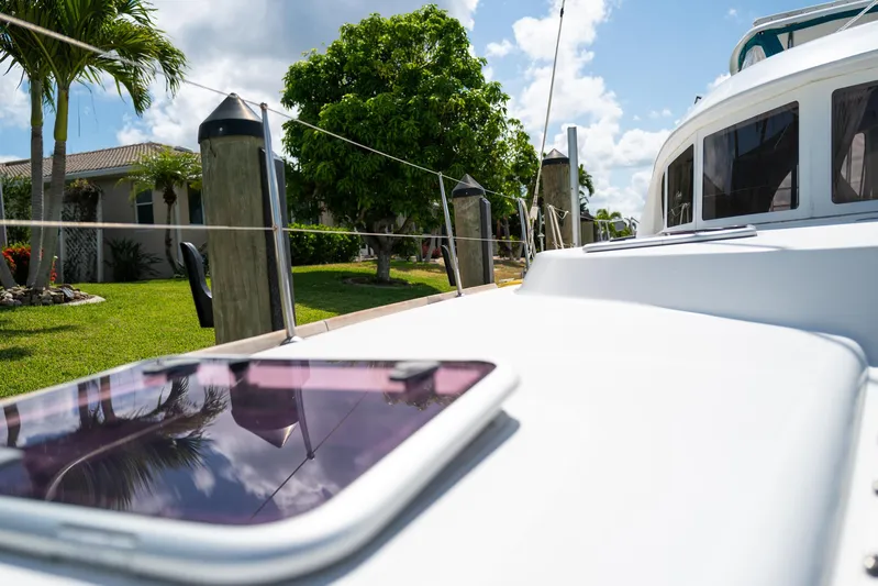 Dream Seeker Yacht Photos Pics 2011 Lagoon 380 S2 yacht docked, with lush greenery and clear skies in the background.