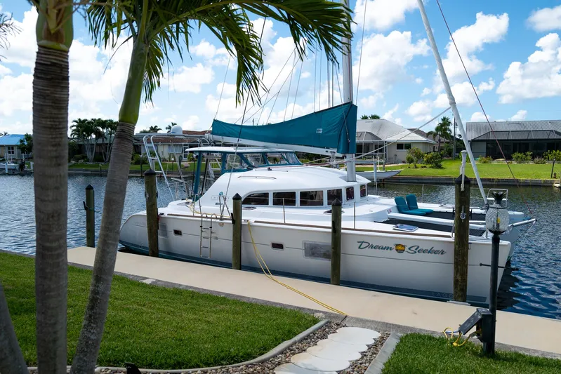 Dream Seeker Yacht Photos Pics 2011 Lagoon 380 S2 catamaran docked by a canal, surrounded by palm trees and clear skies.