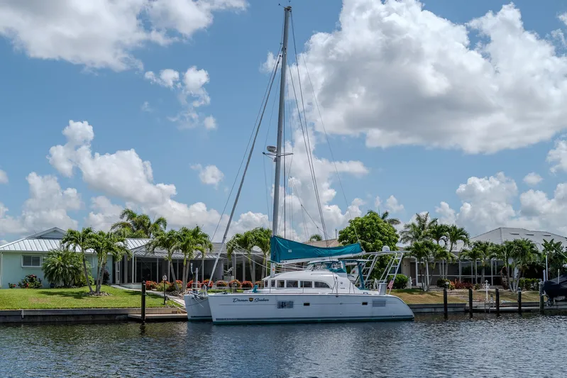 Dream Seeker Yacht Photos Pics 2011 Lagoon 380 S2 catamaran docked by waterfront homes under a blue sky.