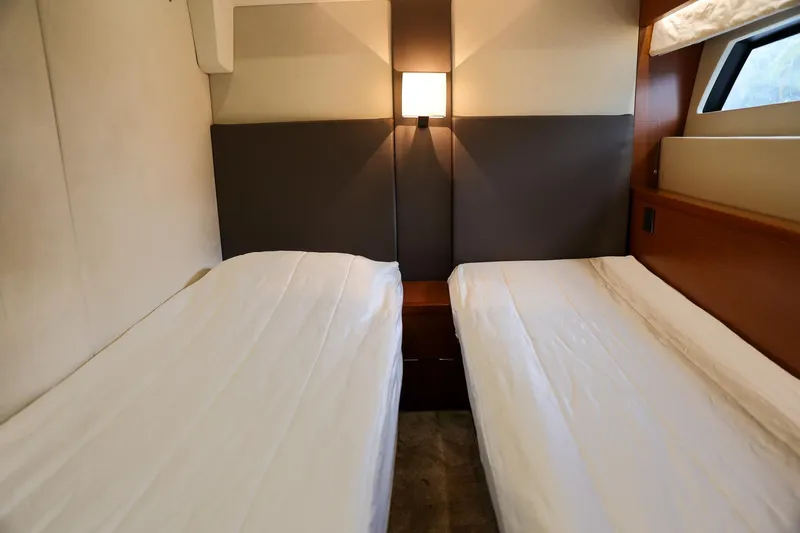  Yacht Photos Pics Twin beds in a 2015 Prestige 550 S yacht cabin, featuring modern design and ambient lighting.