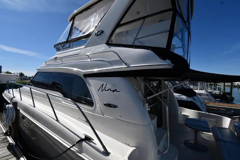 Nina Yacht Photos Pics 2002 Sea Ray 480 Sedan Bridge yacht docked under clear blue sky.