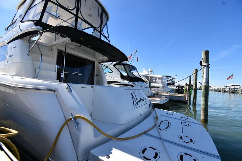 Nina Yacht Photos Pics 2002 Sea Ray 480 Sedan Bridge yacht docked at marina under clear blue sky.