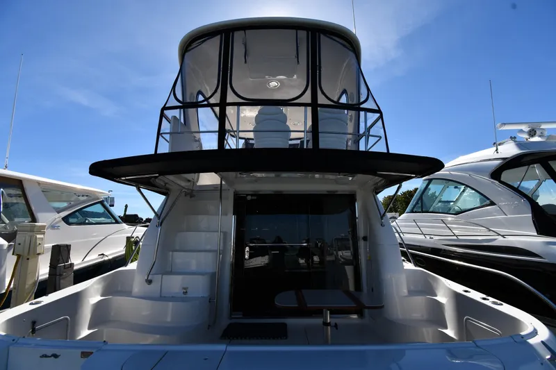 Nina Yacht Photos Pics 2002 Sea Ray 480 Sedan Bridge yacht, rear view, docked under clear blue sky.