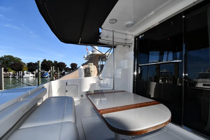 Nina Yacht Photos Pics 2002 Sea Ray 480 Sedan Bridge yacht with outdoor seating and table, docked at marina.