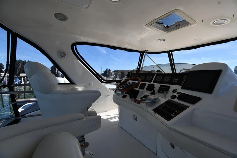 Nina Yacht Photos Pics Interior view of 2002 Sea Ray 480 Sedan Bridge yacht cockpit with steering wheel and controls.