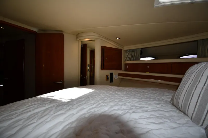 Nina Yacht Photos Pics Interior cabin of 2002 Sea Ray 480 Sedan Bridge yacht, featuring cozy bedding and wooden accents.