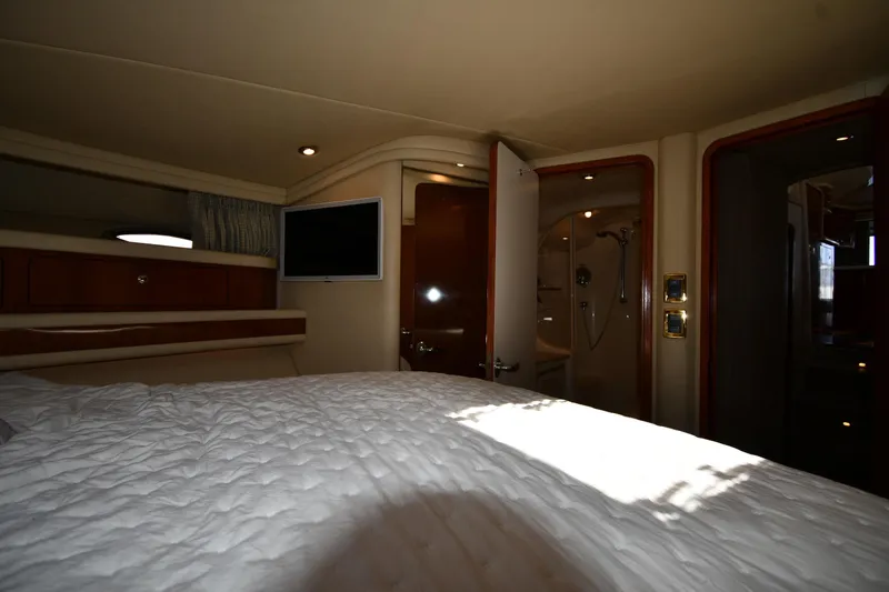 Nina Yacht Photos Pics Interior of 2002 Sea Ray 480 Sedan Bridge yacht, featuring a cozy bedroom and ensuite bathroom.