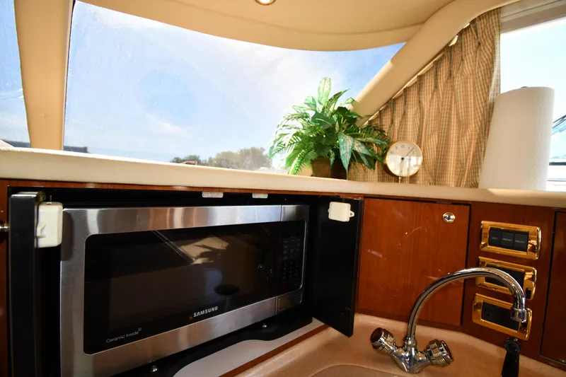 Nina Yacht Photos Pics Interior of 2002 Sea Ray 480 Sedan Bridge with microwave, sink, and decorative plant.