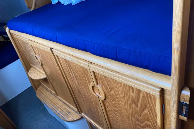 Stimulus Package Yacht Photos Pics 2009 Seawind 36 1000XL interior with blue cushioned bed and wooden cabinetry.