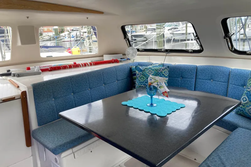 Stimulus Package Yacht Photos Pics Interior of 2009 Seawind 36 1000XL catamaran with blue seating and dining table.