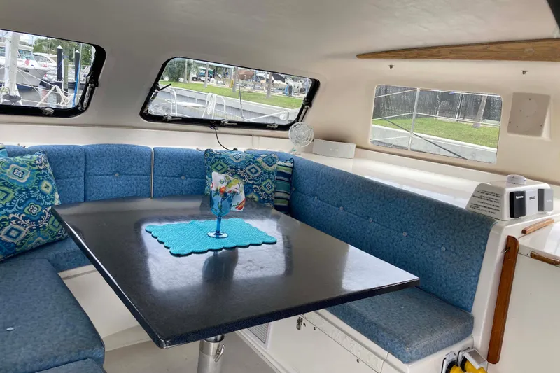 Stimulus Package Yacht Photos Pics Interior of 2009 Seawind 36 1000XL catamaran with blue seating and decorative pillows.