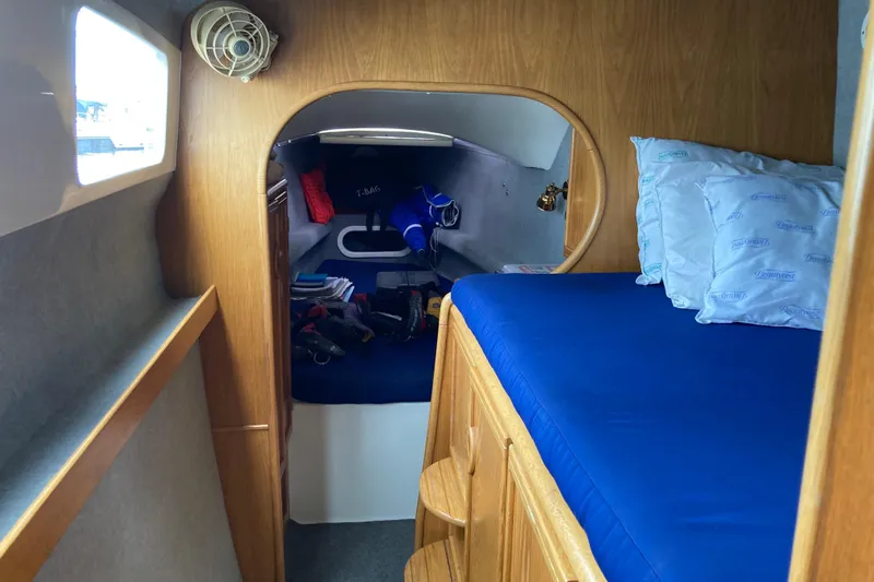 Stimulus Package Yacht Photos Pics Cozy cabin interior of 2009 Seawind 36 1000XL with blue bedding and wooden accents.