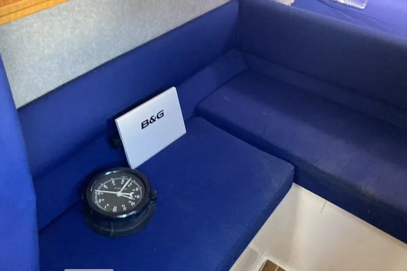 Stimulus Package Yacht Photos Pics Interior of 2009 Seawind 36 1000XL with blue seating and navigation equipment.