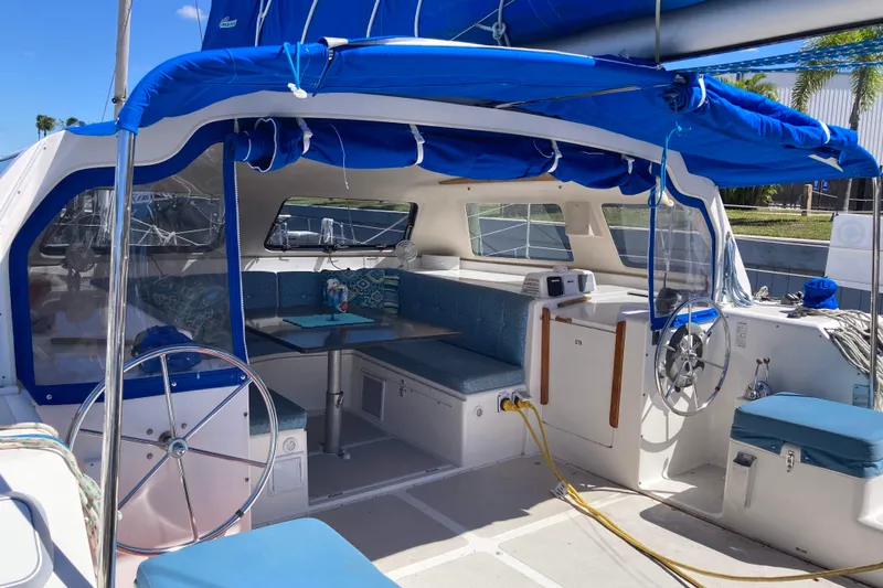 Stimulus Package Yacht Photos Pics 2009 Seawind 36 1000XL catamaran interior with blue seating and helm, docked under sunny skies.