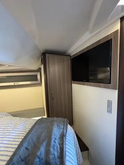  Yacht Photos Pics Interior cabin of 2023 Regal 36 Grande Coupe with bed, TV, and storage.