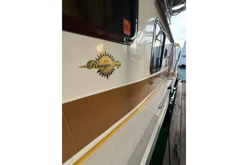  Yacht Photos Pics 2016 Ranger Tugs R-31 CB boat side view with logo and dock background.