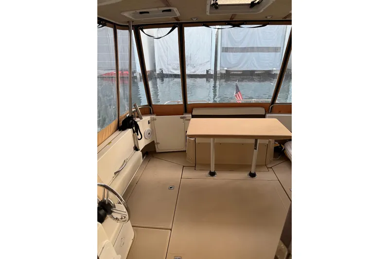  Yacht Photos Pics Interior of 2016 Ranger Tugs R-31 CB boat with table and helm, docked by water.