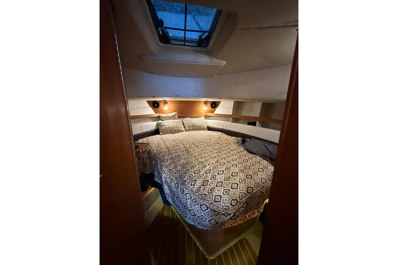  Yacht Photos Pics Cozy cabin interior of 2016 Ranger Tugs R-31 CB with patterned bedding and overhead window.