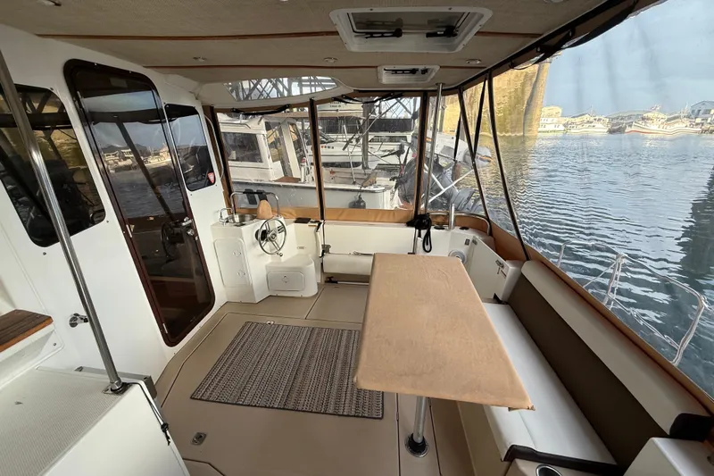  Yacht Photos Pics 2016 Ranger Tugs R-31 CB interior with helm, seating, and marina view.