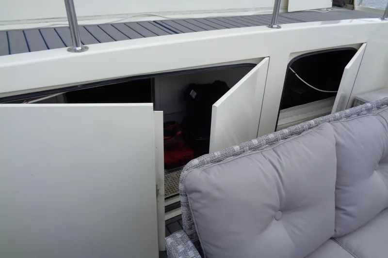 Ivory Lady Yacht Photos Pics Open storage compartments on 1987 Hatteras 70 Cockpit Motor Yacht with cushioned seating.