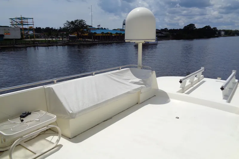 Ivory Lady Yacht Photos Pics 1987 Hatteras 70 Cockpit Motor Yacht deck with seating and radar dome, overlooking calm waters.