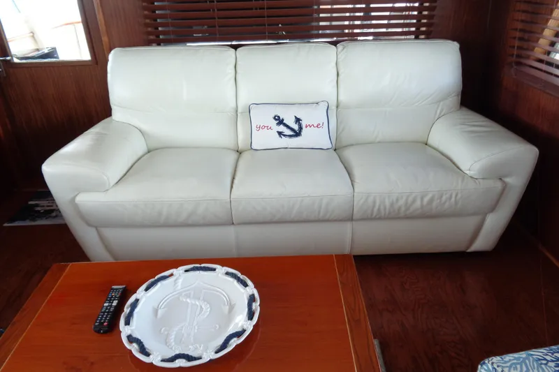 Ivory Lady Yacht Photos Pics White leather sofa with nautical-themed pillow on a 1987 Hatteras 70 Cockpit Motor Yacht.
