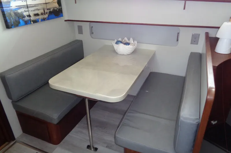 Ivory Lady Yacht Photos Pics Dining area in 1987 Hatteras 70 Cockpit Motor Yacht with gray seating and table.