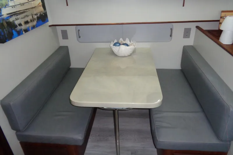 Ivory Lady Yacht Photos Pics Dining area in 1987 Hatteras 70 Cockpit Motor Yacht with gray seating and decorative centerpiece.