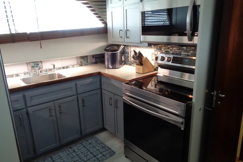 Ivory Lady Yacht Photos Pics Modern kitchen in 1987 Hatteras 70 Cockpit Motor Yacht with stainless steel appliances.