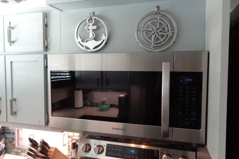 Ivory Lady Yacht Photos Pics Modern kitchen with Samsung microwave, nautical decor, and sleek cabinetry on a 1987 Hatteras yacht.