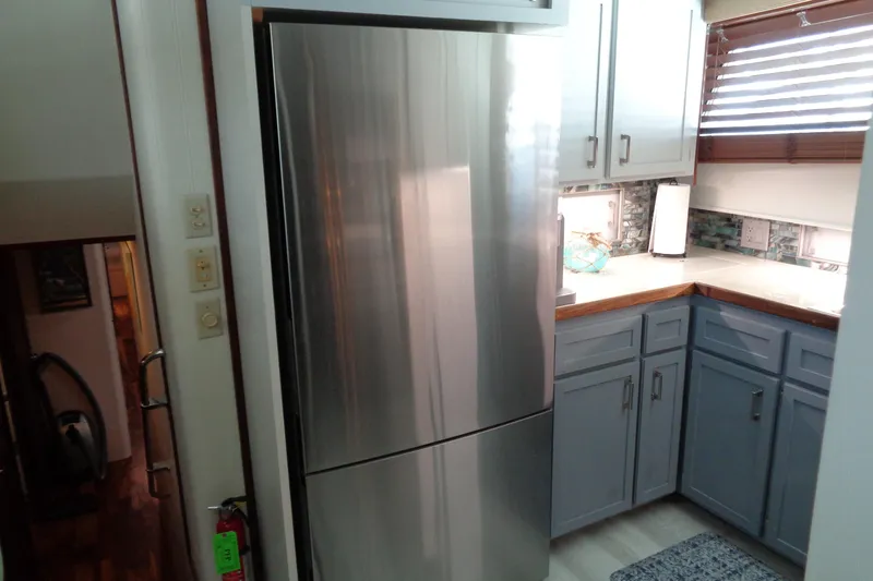 Ivory Lady Yacht Photos Pics Modern kitchen interior on 1987 Hatteras 70 Cockpit Motor Yacht with stainless steel fridge.