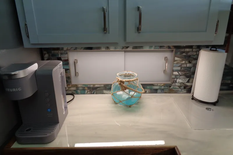 Ivory Lady Yacht Photos Pics Kitchen area of 1987 Hatteras 70 Cockpit Motor Yacht with Keurig and decorative jar.