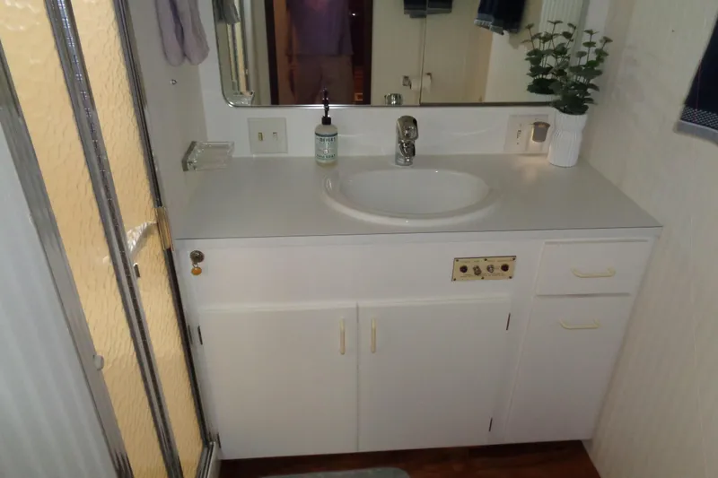 Ivory Lady Yacht Photos Pics Bathroom vanity in 1987 Hatteras 70 Cockpit Motor Yacht with sink, mirror, and shower.