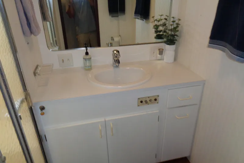 Ivory Lady Yacht Photos Pics Bathroom vanity in 1987 Hatteras 70 Cockpit Motor Yacht with sink, mirror, and decor.