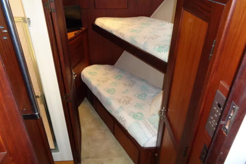 Ivory Lady Yacht Photos Pics 1987 Hatteras 70 Cockpit Motor Yacht cabin with wooden bunk beds and cozy decor.