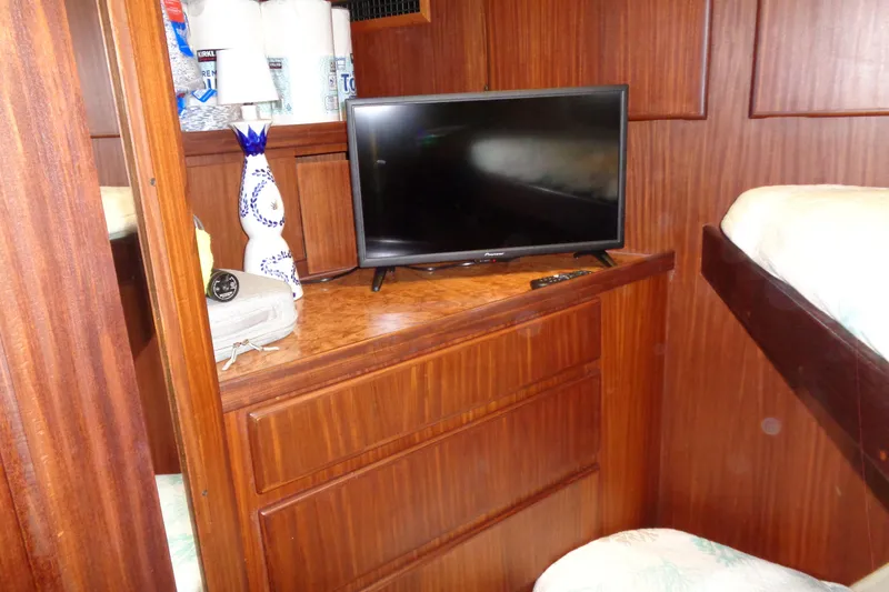 Ivory Lady Yacht Photos Pics Interior of 1987 Hatteras 70 Yacht with TV, wooden cabinetry, and decorative vase.