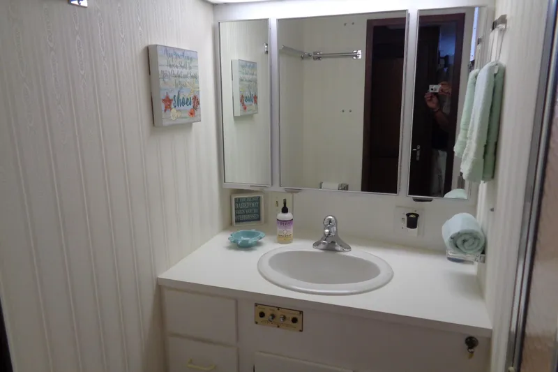 Ivory Lady Yacht Photos Pics Bathroom vanity in 1987 Hatteras 70 Cockpit Motor Yacht with mirror and decor.