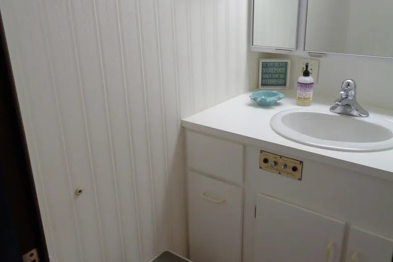 Ivory Lady Yacht Photos Pics Bathroom sink area on 1987 Hatteras 70 Cockpit Motor Yacht, featuring white cabinetry and decor.