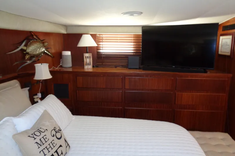 Ivory Lady Yacht Photos Pics Luxurious bedroom interior of 1987 Hatteras 70 Cockpit Motor Yacht with TV and elegant decor.