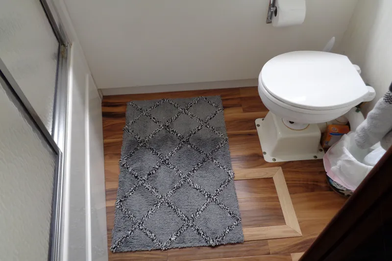 Ivory Lady Yacht Photos Pics Bathroom interior of 1987 Hatteras 70 Cockpit Motor Yacht with toilet and gray rug.